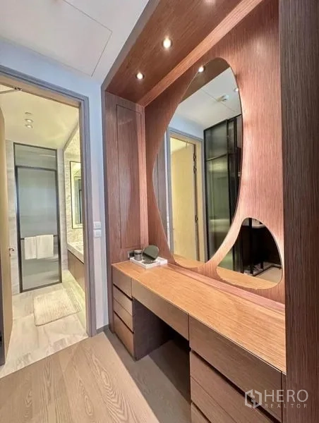 Condominium for rent - Built-in wooden vanity and corridor with warm lighting leading to the bathroom.