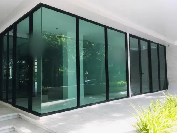 พื้นที่ขายปลีก ให้เช่าในKhlong Toei, Bangkok - หน้าร้านกระจกเต็มผนังมุมอาคาร พร้อมทางเดินมีหลังคาและต้นไม้ด้านหน้า