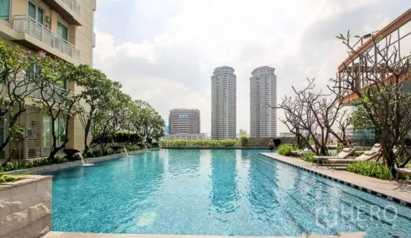 Condominium for sale in Sathon, Bangkok - Outdoor swimming pool at the condominium with city skyline views and sun loungers.