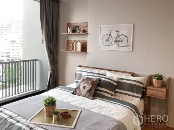 คอนโด ให้เช่าในBang Rak, Bangkok - ห้องนอนโทนอบอุ่น ชุดเครื่องนอนลายทาง ชั้นลอย และทางออกสู่ระเบียง.