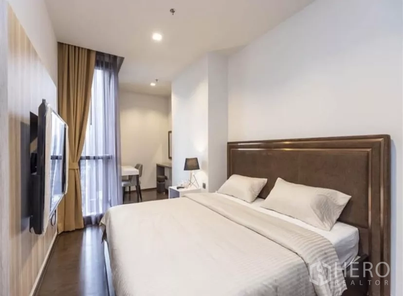 公寓 出租在Ratchathewi, Bangkok - 主卧另一角，壁挂电视、落地窗与小型学习角。