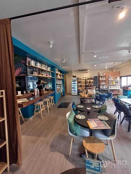 พื้นที่ขายปลีก ให้เช่าในWatthana, Bangkok - มุมที่นั่งสไตล์คาเฟ่ข้างบาร์สีน้ำเงินและชั้นโชว์ของ