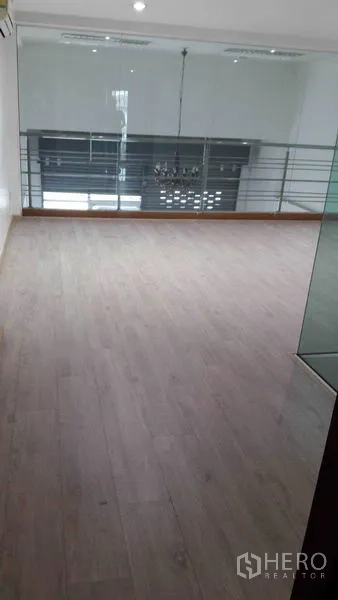 Office Space for rent in Bueng Kum, Bangkok - Mezzanine office area with light wood flooring and glass balustrade.