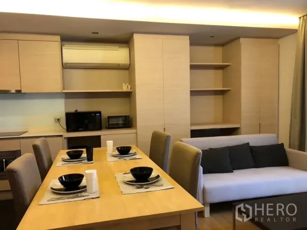 คอนโด ให้เช่าในWatthana, Bangkok - พื้นที่นั่งเล่นและกินข้าวแบบโอเพนแพลน พร้อมชั้นวางของและโซฟา