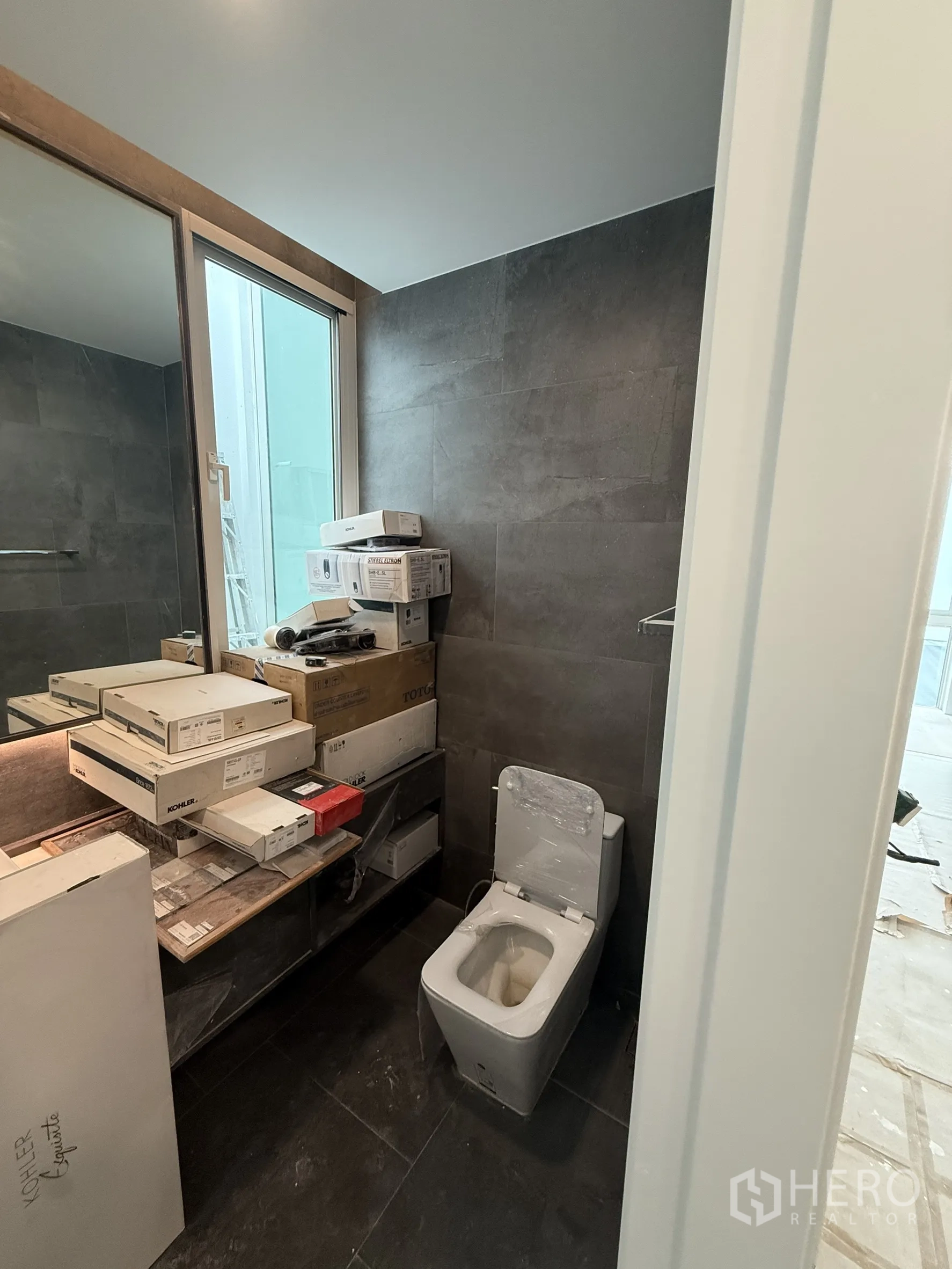 Detached House for sale in Bang Phli, Samut Prakan - Guest bathroom with toilet, large mirror and boxed fixtures awaiting install.