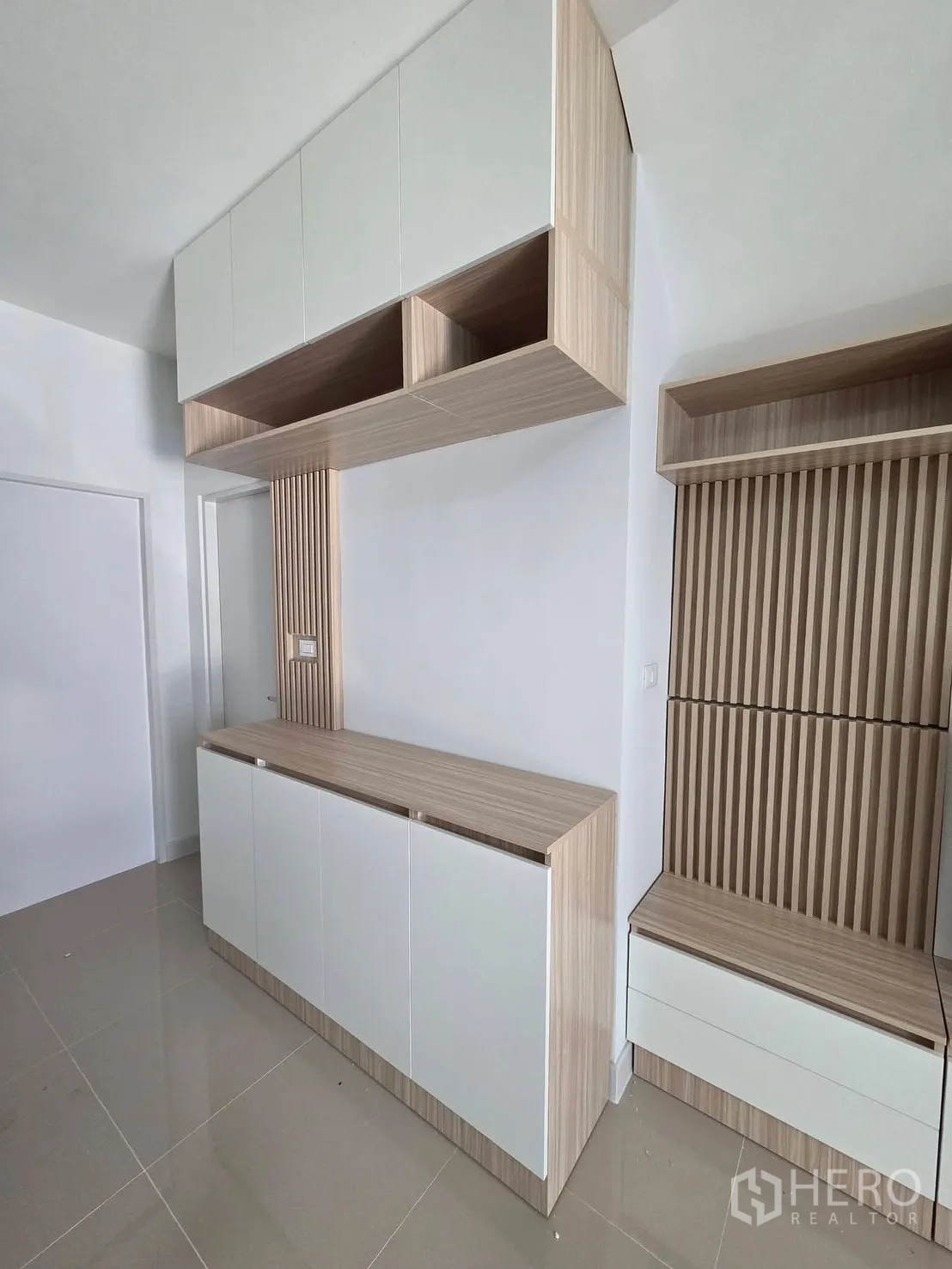 Townhouse for rent in Bang Phli, Samut Prakan - Built-in storage cabinets and slatted wall panels in a minimalist living space.