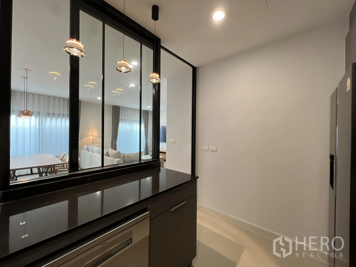 Detached House for rent in Prawet, Bangkok - Kitchen workspace with pendant lights and glass divider.