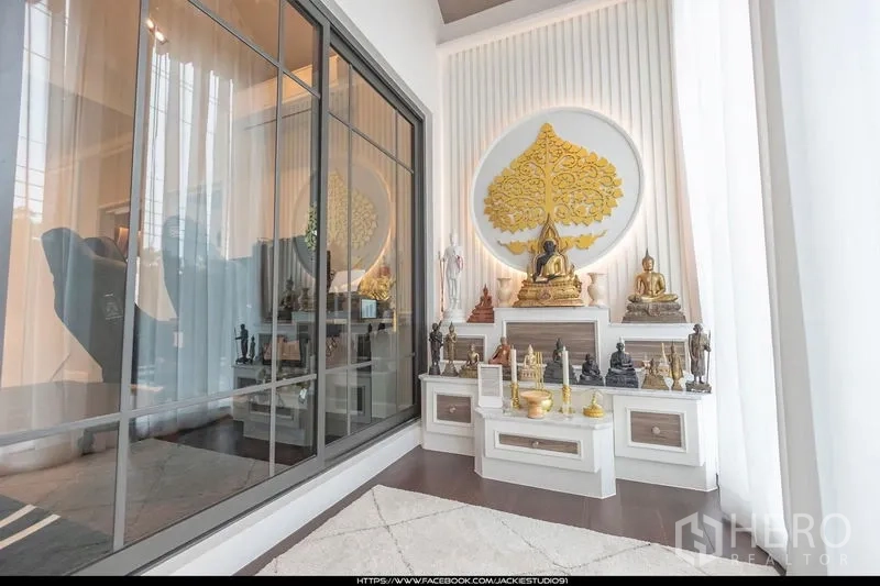 Detached House for sale in Pak Kret, Nonthaburi - Bright shrine room with built‑in altar and golden bodhi tree wall art beside large glass partition.