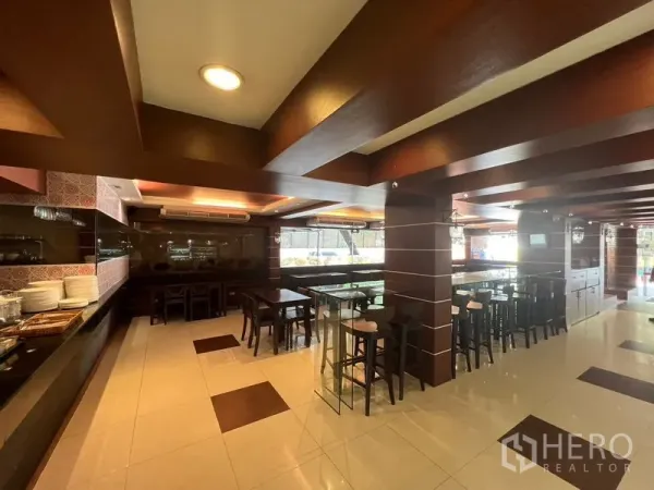 零售空间 出租或出售在Khlong Toei, Bangkok - 宽敞就餐大厅，瓷砖地面、木梁与多组座位。