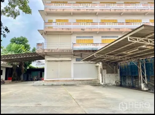 工厂 出租在Chom Thong, Bangkok - 工厂正立面，宽阔混凝土院子与金属雨棚。