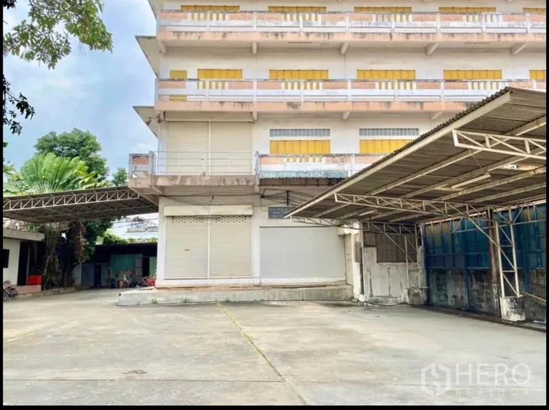 工厂 出租在Chom Thong, Bangkok - 工厂正立面，宽阔混凝土院子与金属雨棚。