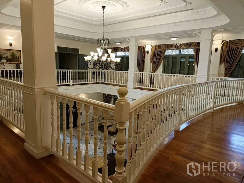 Detached House for rent or sale in Krathum Baen, Samut Sakhon - Curved upper gallery with white balustrade and chandelier above the hall.