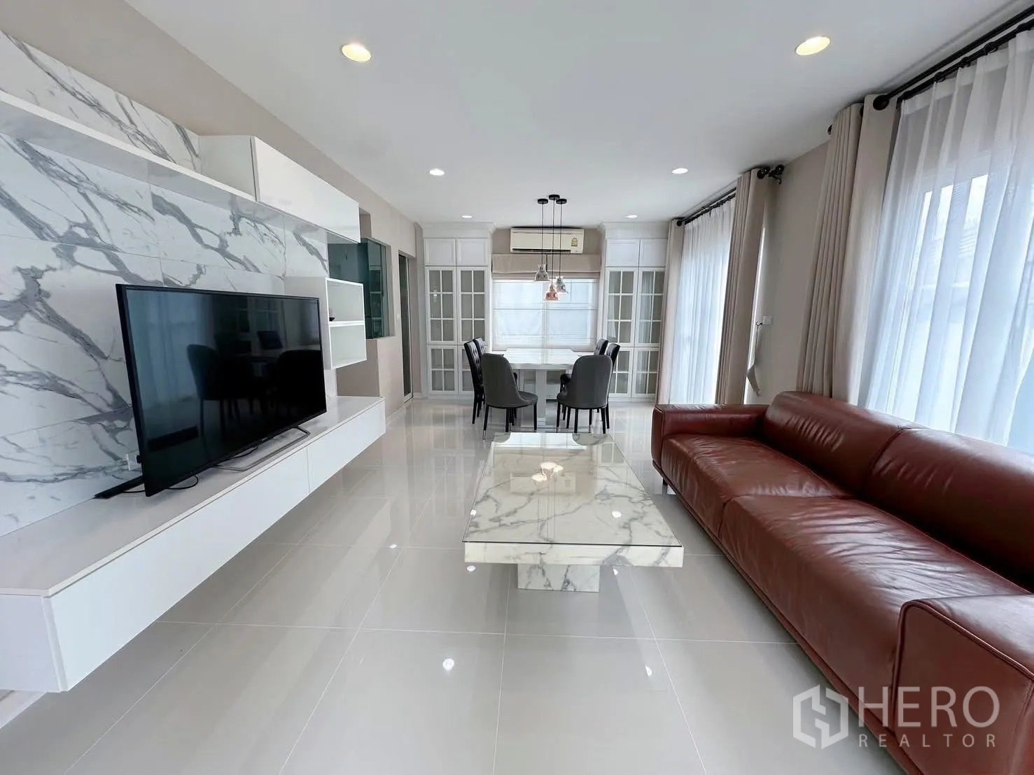 独立式住宅 出租或出售在Bang Phli, Samut Prakan - 长景客厅与餐区，白色电视柜配大理石茶几