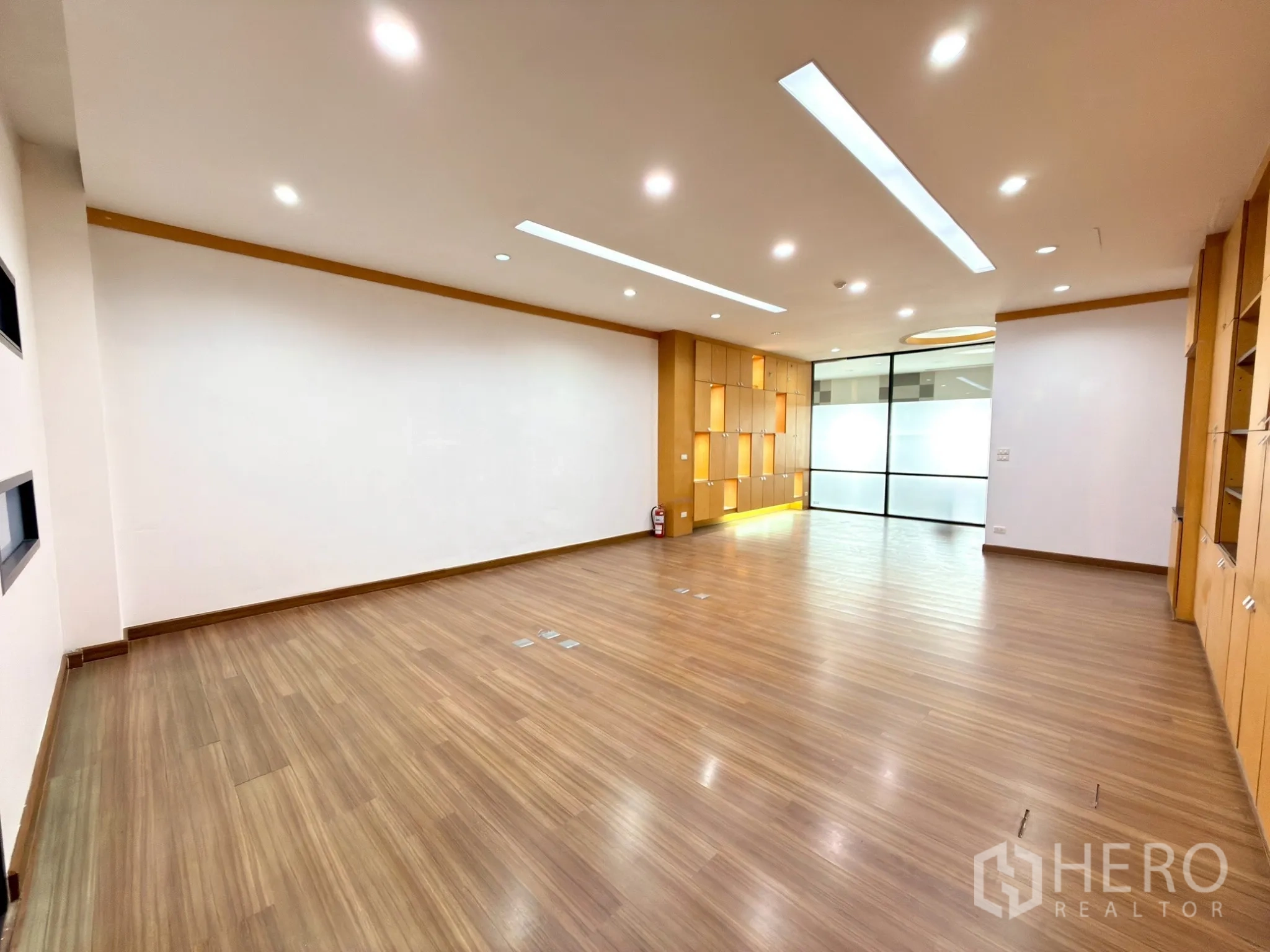Office Space for rent in Watthana, Bangkok - Wide workspace with spotlighted display niches and a glass partition to anteroom.