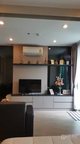 公寓 出租在Bang Rak, Bangkok - 内置电视柜与空调，搭配窗帘与装饰架。