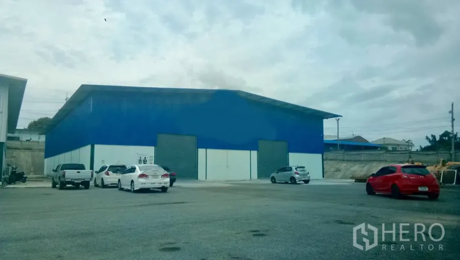 货栈 出租在Si Racha, Chon Buri - 蓝色仓库外观，双卷帘门与宽阔停车及货车通道