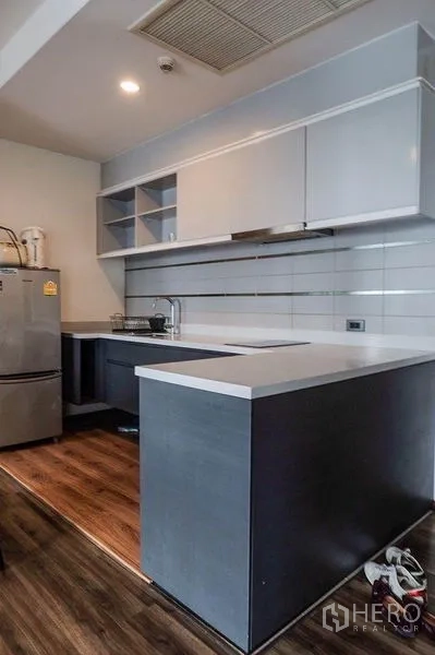 คอนโด ให้เช่าในKhlong Toei, Bangkok - เคาน์เตอร์ครัวรูปตัวแอล ตู้แขวน และเตาไฟฟ้า