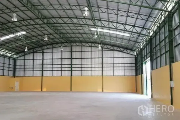 Warehouse for rent in Lat Krabang, Bangkok - Wide-span warehouse interior with concrete floor, multiple bay doors and ventilation panels.