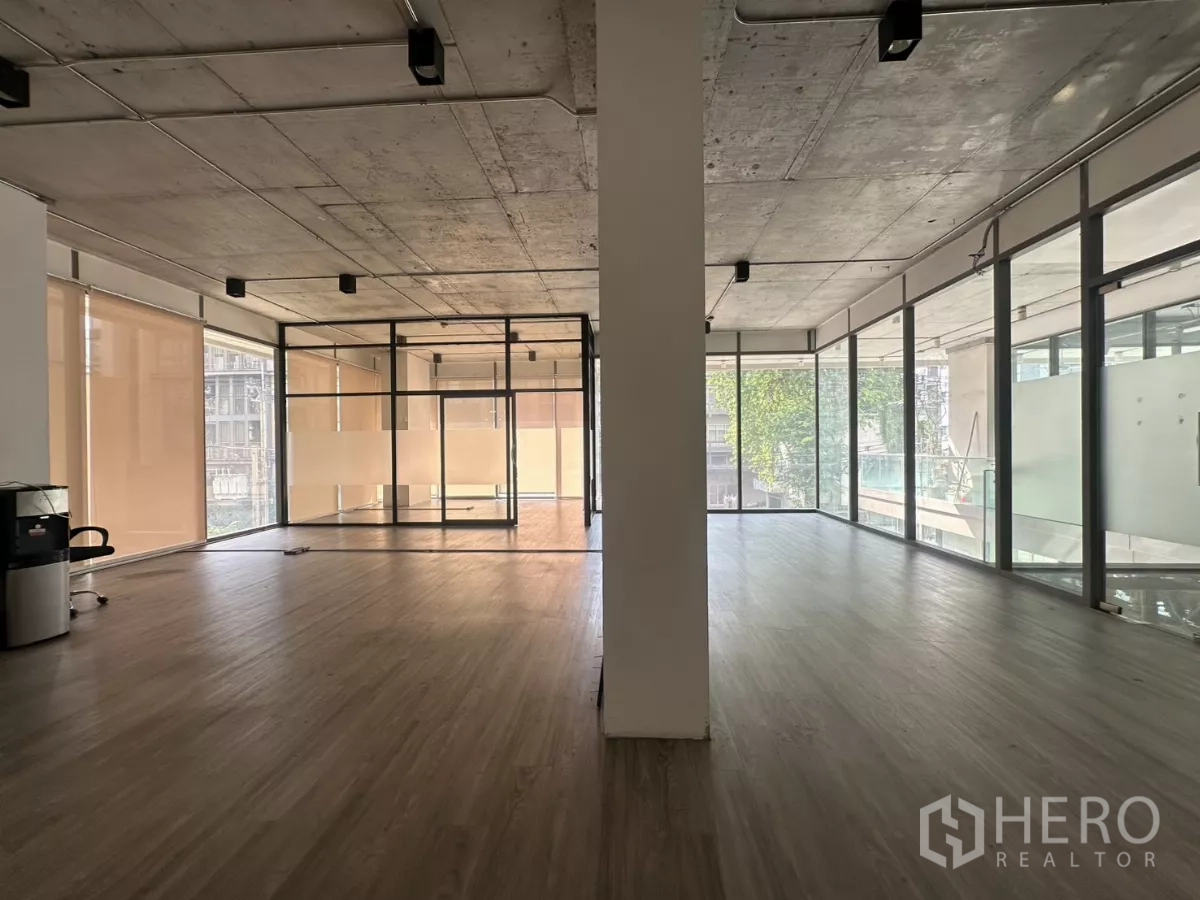 零售空间 出租 - 宽阔视角的转角单位，配有卷帘、中间立柱、轨道灯与整面落地玻璃。