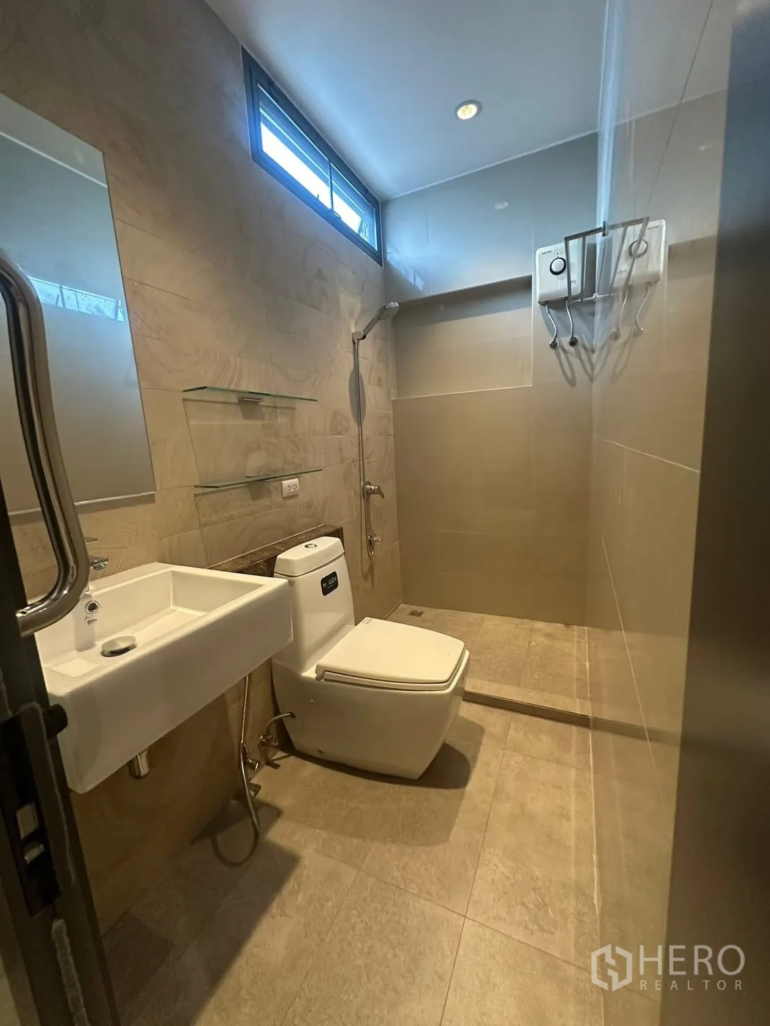 บ้าน for rent in Watthana, Bangkok - ห้องน้ำดีไซน์เรียบหรู มีฝักบัววอล์กอิน ชั้นวางติดผนัง อ่างสี่เหลี่ยม และโถสุขภัณฑ์ใต้ช่องแสงสูง