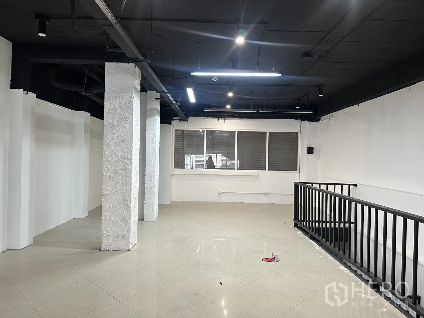 零售空间 for rent in Pathum Wan, Bangkok - 楼上空间设照明、立柱与楼梯旁金属护栏