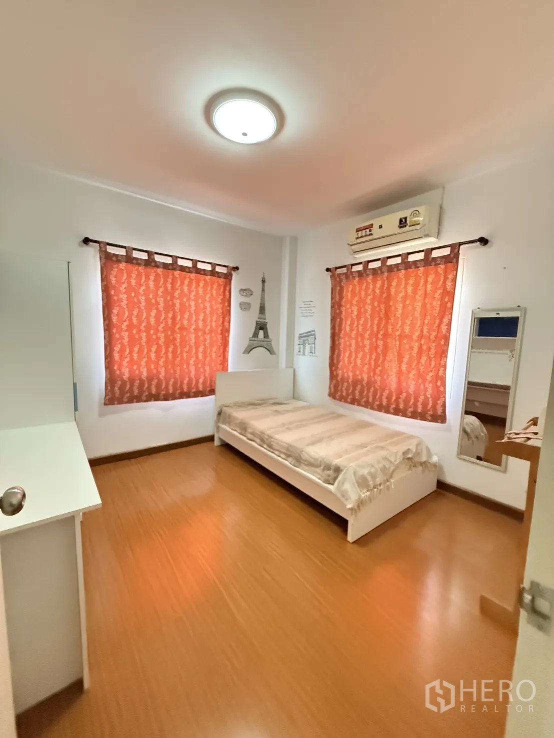 Detached House for rent in Lam Luk Ka, Pathum Thani - Bedroom with single bed, desk, red curtains, and wood-style flooring.