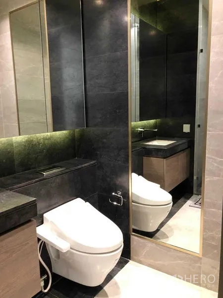 Condominium for rent - Modern bathroom with dark stone tiles, large mirror and contemporary fixtures.