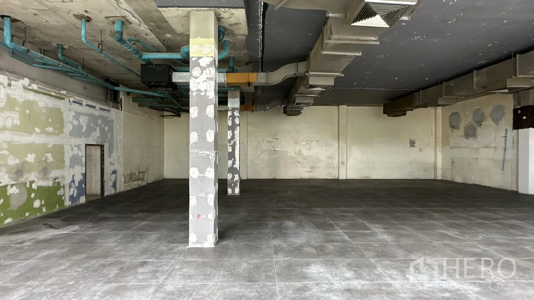 Retail Space for rent in Watthana, Bangkok - Exposed ductwork and columns in an empty tiled retail area.