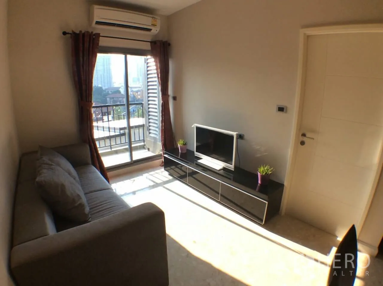 คอนโด ให้เช่าในKhlong Toei, Bangkok - ห้องนั่งเล่นสว่างด้วยประตูกระจกบานเลื่อนออกสู่ระเบียง มีแอร์และชั้นวางทีวี