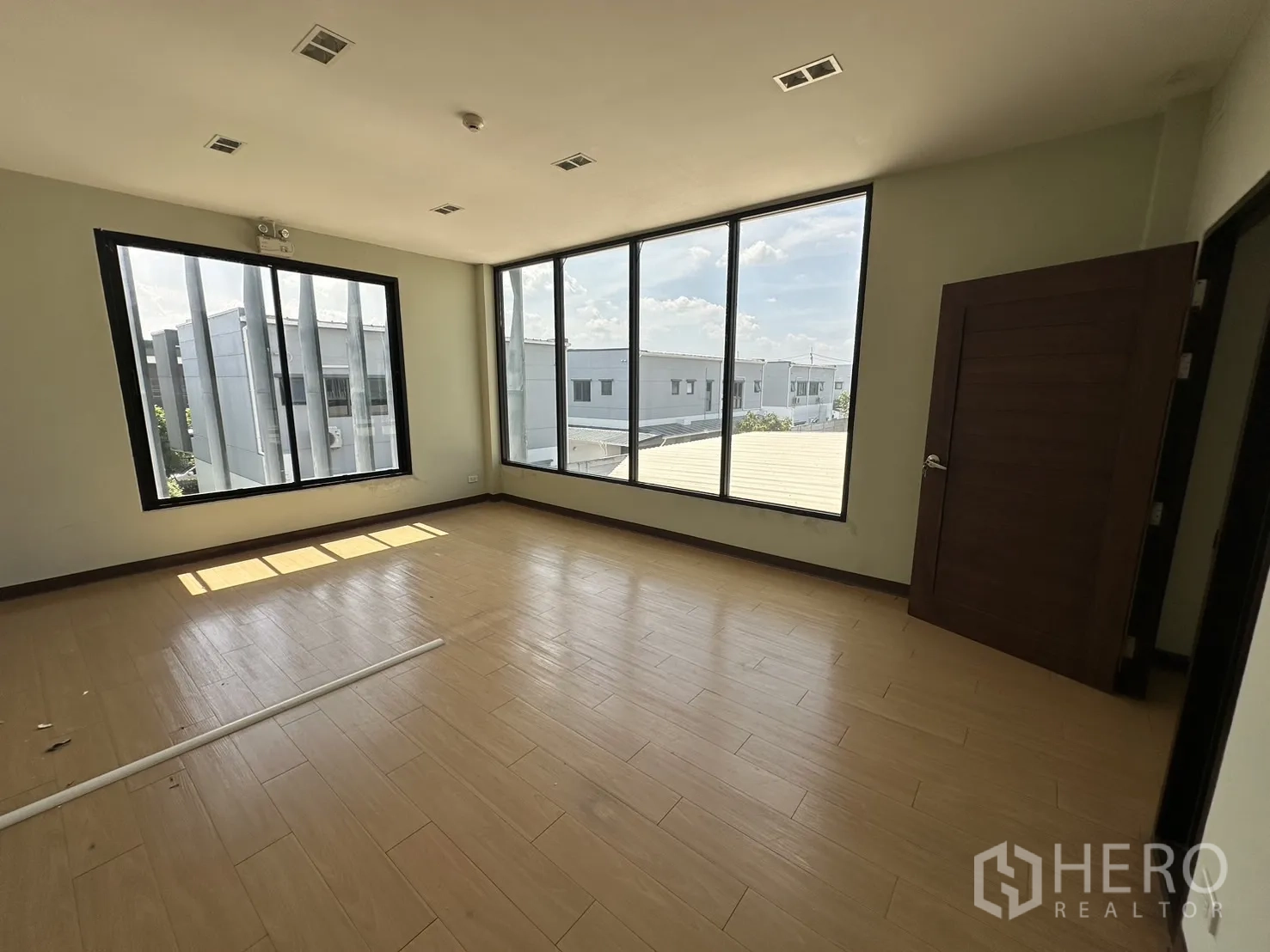 Home Office for rent in Prawet, Bangkok - Private office with dual-aspect windows and wood-look flooring.