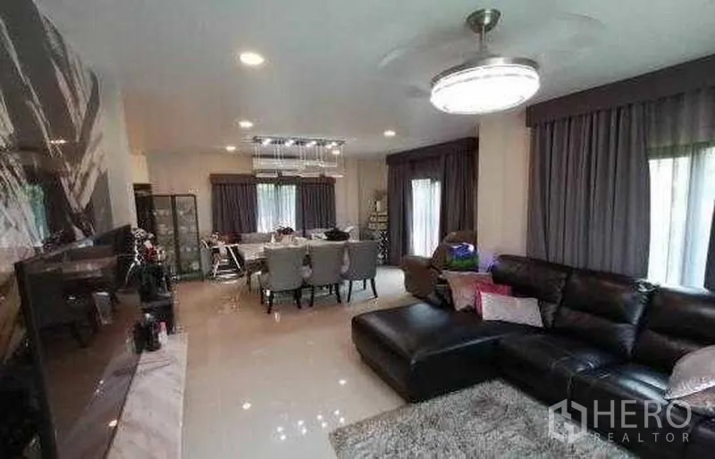 Detached House for sale in Bang Phli, Samut Prakan - Open-plan living and dining area with chandelier and leather sofa in a Bang Phli house.