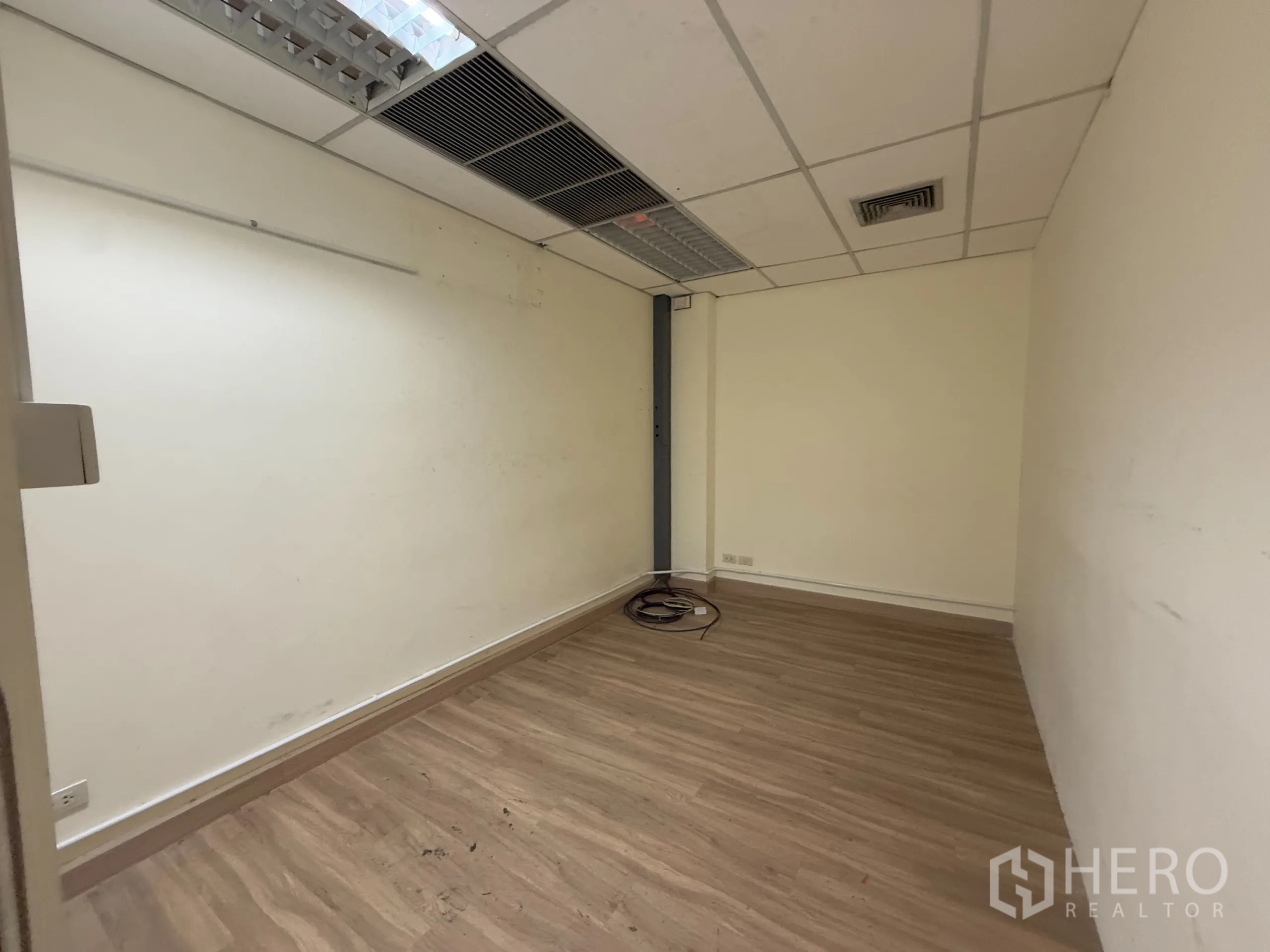 办公空间 出租在Chatuchak, Bangkok - 小型办公室，木纹地板、白色墙面与吊顶，设有空调出风口。