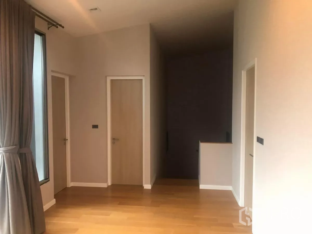Detached House for rent in Bang Kapi, Bangkok - Spacious landing with large window, multiple doors and wood flooring.