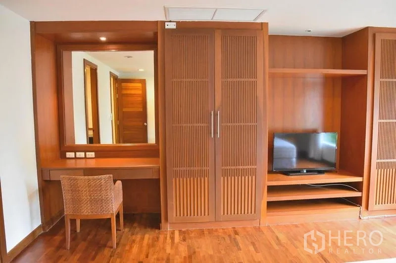 房间 出租在Sathon, Bangkok - 卧室一角设梳妆台、电视柜与木质橱柜。