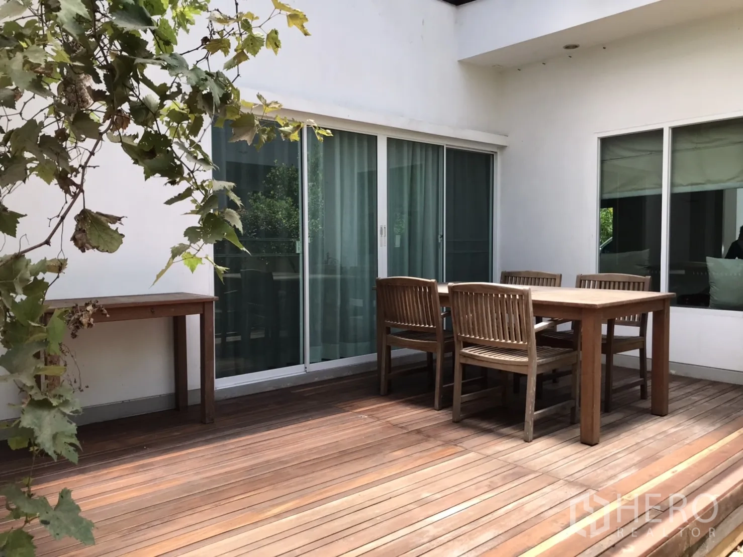 独立式住宅 出租或出售在Saphan Sung, Bangkok - 大型木质露台，户外餐桌与推拉玻璃门。