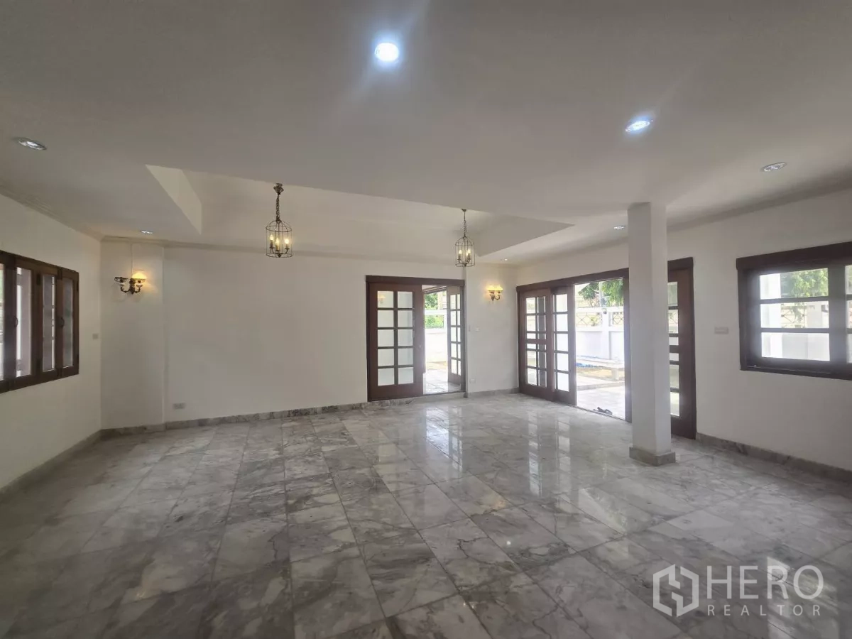 独立式住宅 出租在Phra Khanong, Bangkok - 开放式起居空间，大理石地砖、法式玻璃门通向露台与吊灯