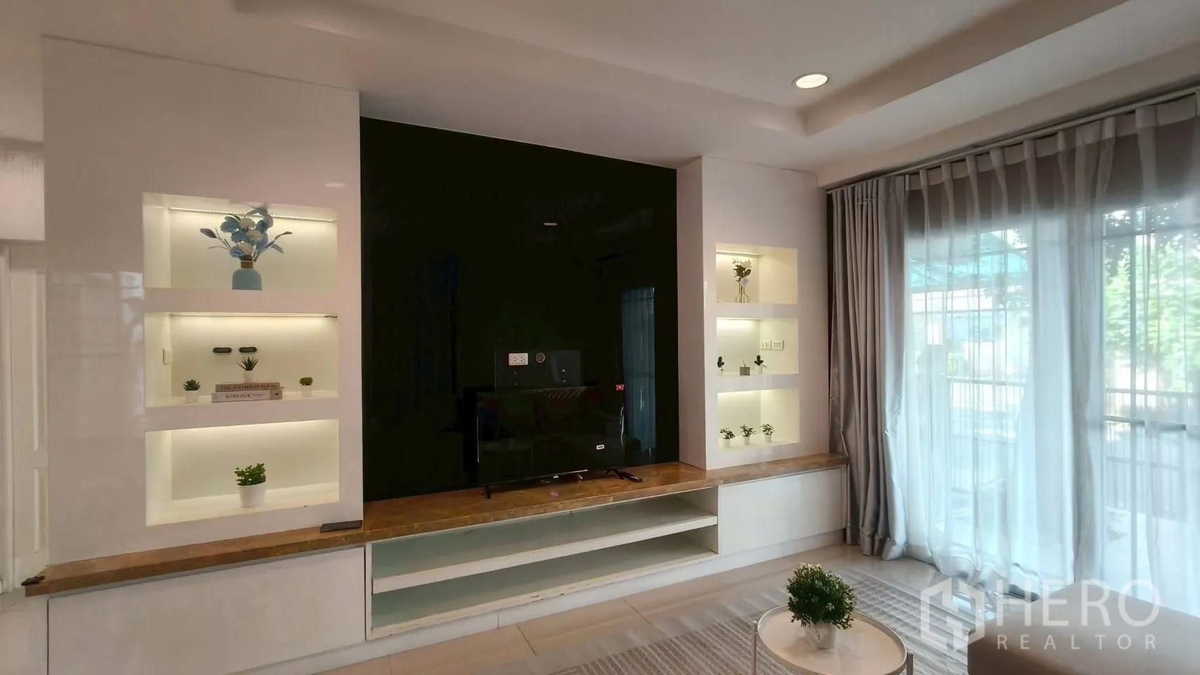 บ้าน ให้เช่าหรือขายในMueang Samut Prakan, Samut Prakan - ผนังทีวีบิวท์อินพร้อมชั้นโชว์ไฟ LED และประตูกระจกบานเลื่อนพร้อมม่านโปร่ง