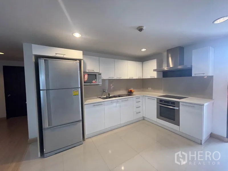 อพาร์ทเมนท์ ให้เช่าในKhlong Toei, Bangkok - ครัวตัวแอลโทนขาวสมัยใหม่ พร้อมเตาอบ เตาไฟฟ้า และตู้เย็นสแตนเลส