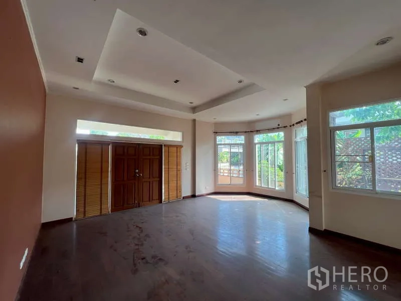 独立式住宅 出租在Watthana, Bangkok - 前客厅，飘窗、木质双开门与层次吊顶。