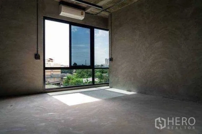 Office Space for rent or sale in Lak Si, Bangkok - Unfurnished office room with large window, air conditioner, and city and greenery views.