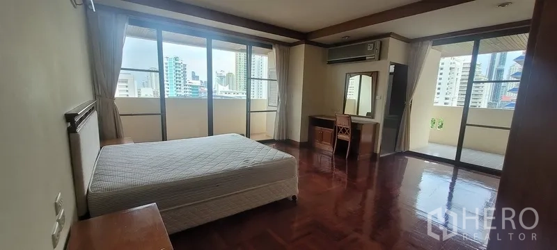 คอนโด ให้เช่าในWatthana, Bangkok - ห้องนอนมุมมีประตูออกระเบียงหลายด้าน เห็นวิวเมือง พื้นไม้ และโต๊ะเครื่องแป้ง