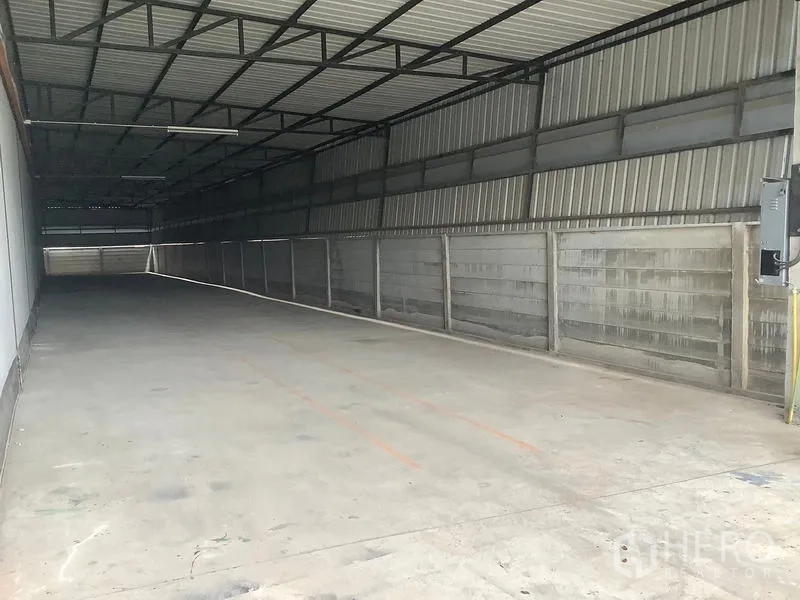 工厂 出租在Ban Phaeo, Samut Sakhon - 建筑侧面，长条有顶装卸通道与金属墙面。