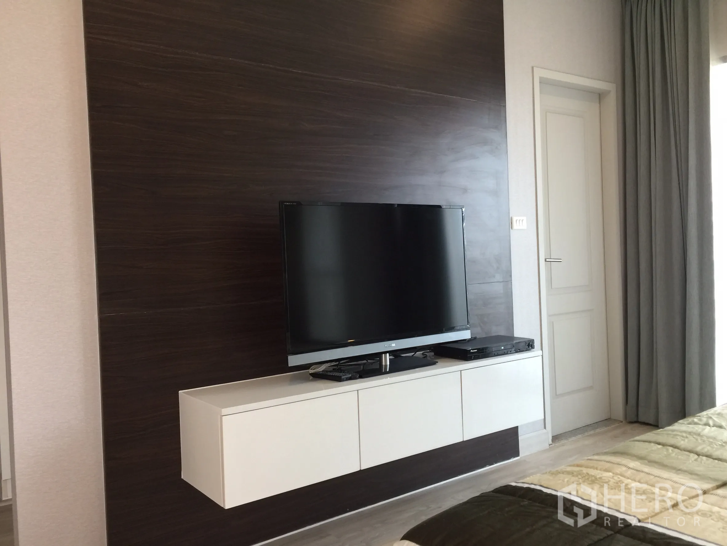 คอนโด ให้เช่าหรือขายในBangkok - ผนังลายไม้เข้มติดทีวีพร้อมตู้ลอยในห้องนอน