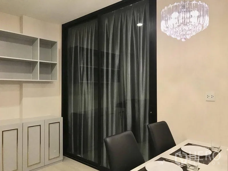 Condominium for rent in Huai Khwang, Bangkok - Dining area with two-seat table, crystal chandelier and sliding glass partition.