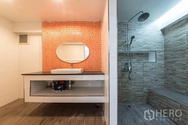 Home Office for sale in Bang Kho Laem, Bangkok - Modern bathroom with orange backsplash, round mirror and stone-tiled rain shower.