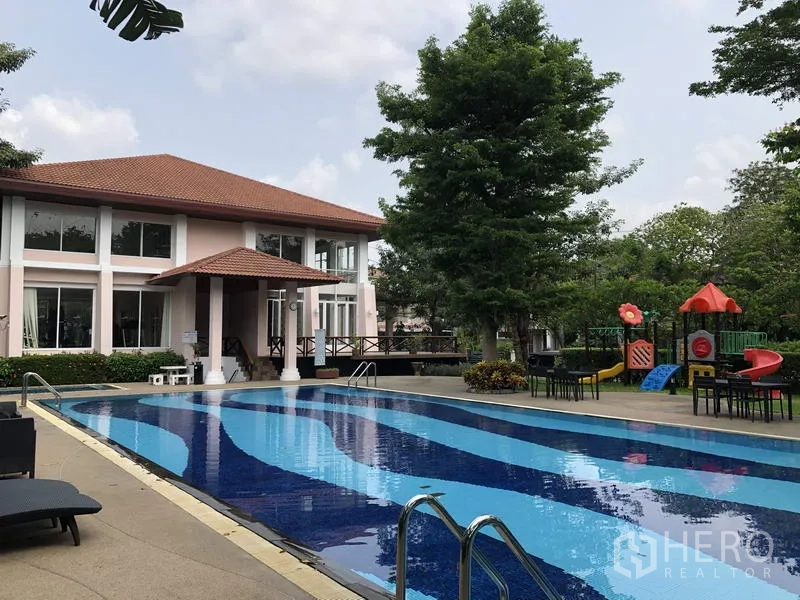บ้าน ขายในWang Thonglang, Bangkok - สระว่ายน้ำคลับเฮาส์มีเลนว่ายน้ำ ที่นั่งริมสระ และสนามเด็กเล่นท่ามกลางต้นไม้.