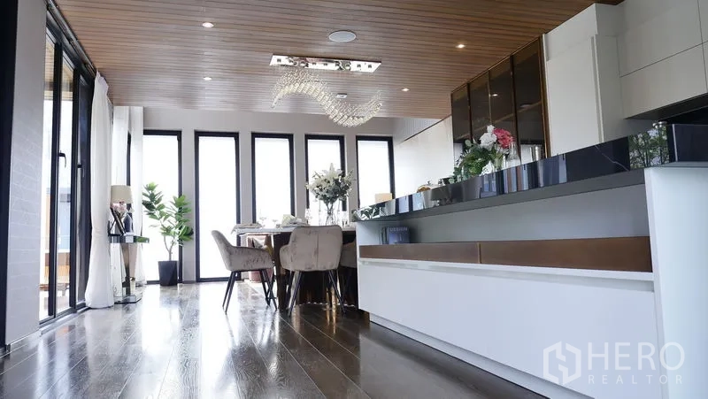 独立式住宅 出售在Prawet, Bangkok - 开放式厨房与餐厅，长中岛、木天花与高窗。