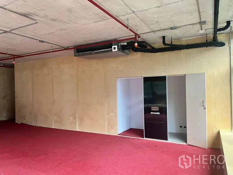 พื้นที่ขายปลีก ให้เช่าในWatthana, Bangkok - ผนังชั้นบนพร้อมประตูและแผงบิวท์อิน ใต้เพดานโชว์ท่อ พรมสีแดง