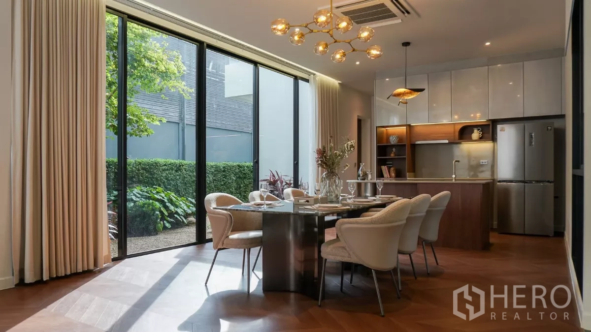 独立式住宅 出租或出售在Bang Kapi, Bangkok - 餐区临近落地玻璃与露台，吊灯温馨，餐桌布置完整。