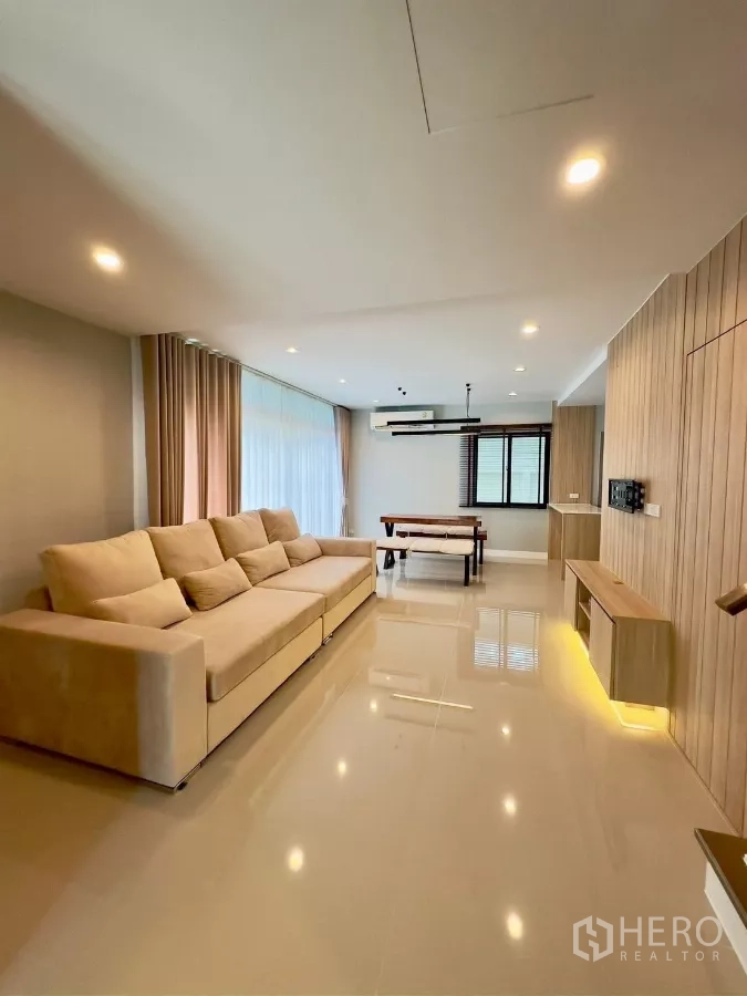 Detached House for rent in Samut Prakan - Spacious living room with built-in media shelf, recessed lighting and tiled floors.
